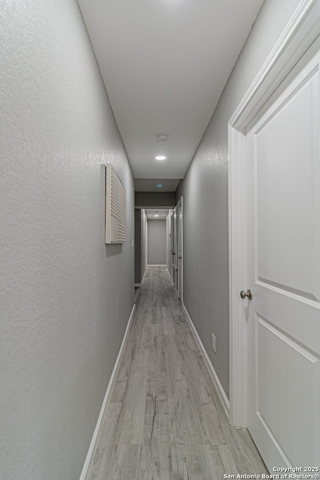 4935 Bartmer Ave, San Antonio, TX 78228 - corridor featuring light wood-type flooring and a textured wall