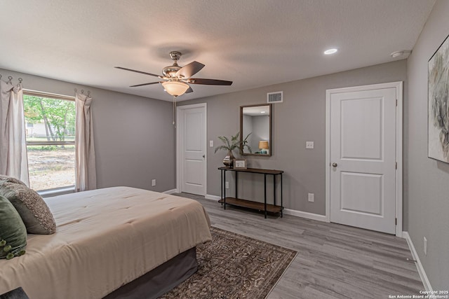 4935 Bartmer Ave, San Antonio, TX 78228 - bedroom featuring wood finished floors, a textured ceiling, and a ceiling fan