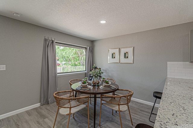 4935 Bartmer Ave, San Antonio, TX 78228 - dining room with light wood-style floors and a textured ceiling