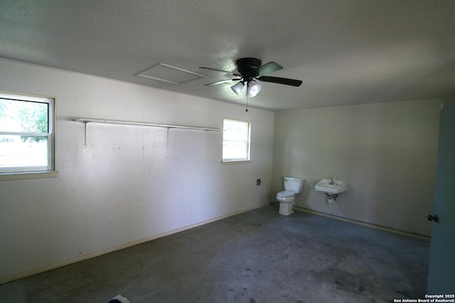 206 Alvina, Castroville, TX 78009 - bathroom featuring concrete flooring, toilet, a textured ceiling, and a ceiling fan