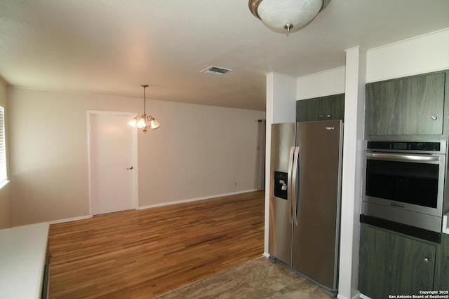 206 Alvina, Castroville, TX 78009 - kitchen featuring appliances with stainless steel finishes, light wood finished floors, a chandelier, and decorative light fixtures