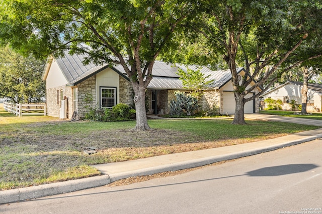 101 Country Ln, Castroville, TX 78009 - view of front facade featuring stone siding, a standing seam roof, metal roof, driveway, and solar panels