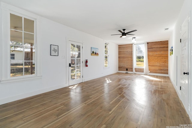 30951 Blanco Rd, Bulverde, TX 78163 - empty room with ceiling fan, wood finished floors, plenty of natural light, and wooden walls