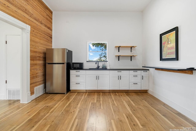 30951 Blanco Rd, Bulverde, TX 78163 - kitchen with freestanding refrigerator, light wood-type flooring, a sink, and white cabinetry
