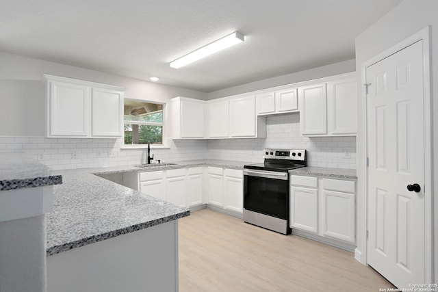 9814 Shawnee, Converse, TX 78109 - kitchen featuring electric stove, a sink, light stone counters, white cabinets, and backsplash