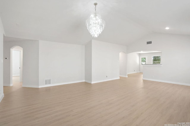 9814 Shawnee, Converse, TX 78109 - unfurnished living room with arched walkways, light wood-style flooring, vaulted ceiling, baseboards, and a chandelier