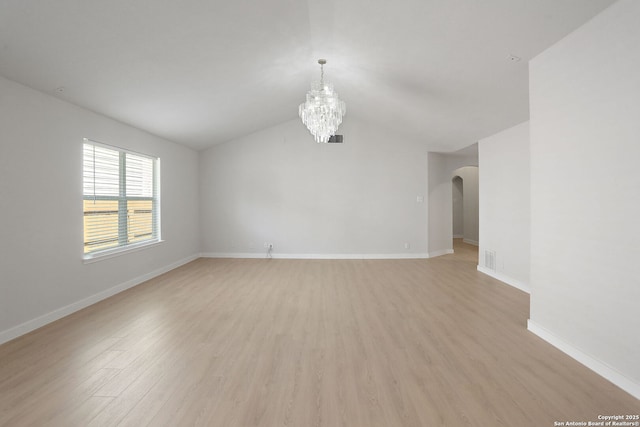 9814 Shawnee, Converse, TX 78109 - unfurnished room with a chandelier, light wood finished floors, arched walkways, baseboards, and vaulted ceiling