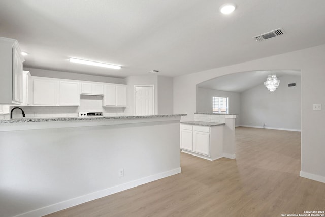 9814 Shawnee, Converse, TX 78109 - kitchen featuring tasteful backsplash, a chandelier, a peninsula, baseboards, and arched walkways