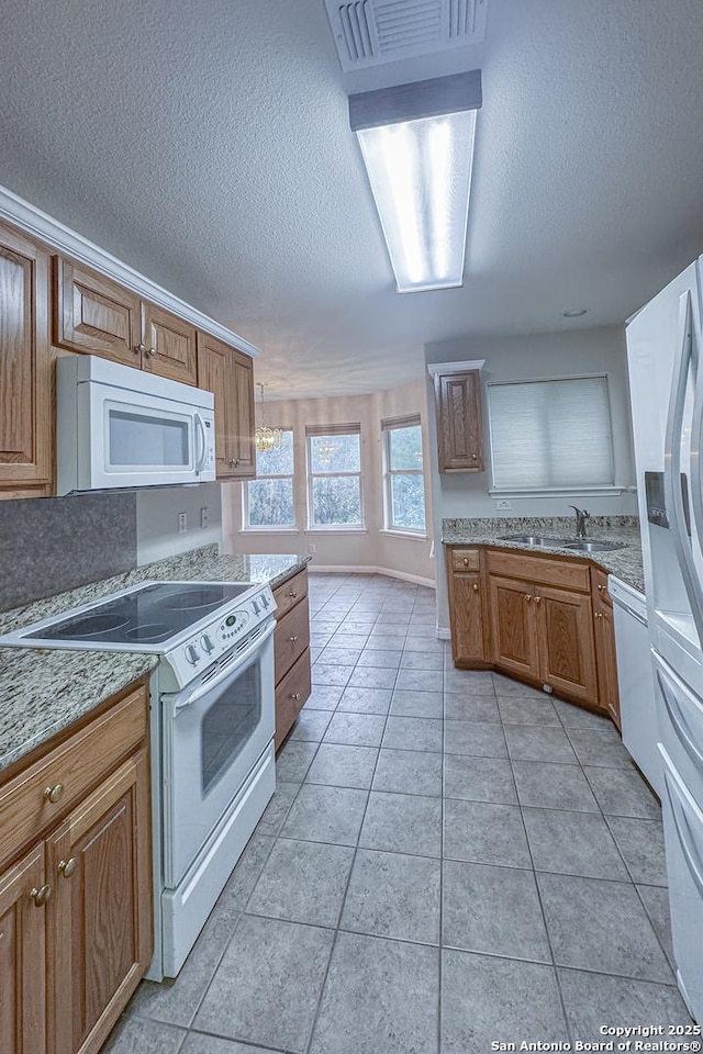 424 Mount Joy, New Braunfels, TX 78130 - kitchen featuring white appliances, a textured ceiling, a sink, a chandelier, and brown cabinetry