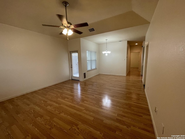 104 W W Unit 104, Comfort, TX 78013 - unfurnished room featuring wood finished floors, a chandelier, a ceiling fan, and baseboards