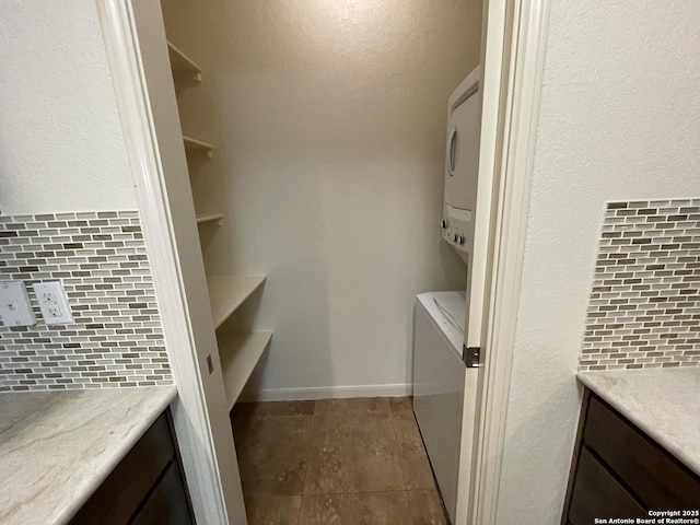 104 W W Unit 104, Comfort, TX 78013 - laundry area featuring stacked washer and clothes dryer and dark tile patterned flooring
