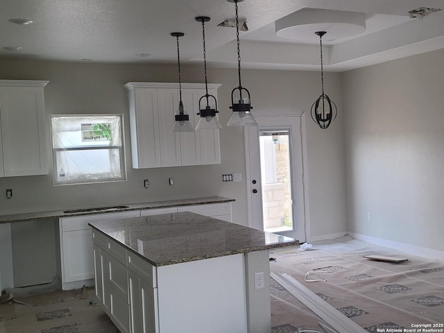 52 Peach Tree, Poteet, TX 78065 - kitchen featuring white cabinetry, a kitchen island, pendant lighting, dark stone countertops, and a textured ceiling