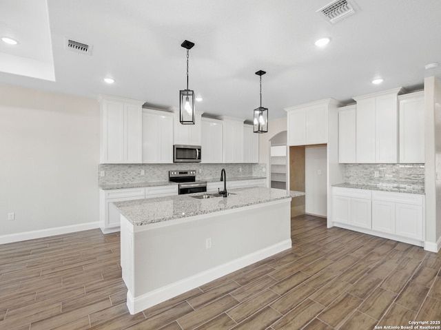 52 Peach Tree, Poteet, TX 78065 - kitchen featuring stainless steel appliances, a sink, light wood finished floors, decorative backsplash, and recessed lighting