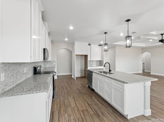52 Peach Tree, Poteet, TX 78065 - kitchen with a sink, arched walkways, appliances with stainless steel finishes, white cabinetry, and recessed lighting