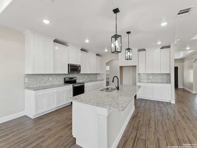 52 Peach Tree, Poteet, TX 78065 - kitchen featuring appliances with stainless steel finishes, a sink, baseboards, dark wood-type flooring, and decorative backsplash