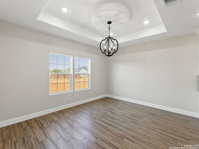 52 Peach Tree, Poteet, TX 78065 - empty room featuring a raised ceiling, wood finished floors, a chandelier, baseboards, and recessed lighting