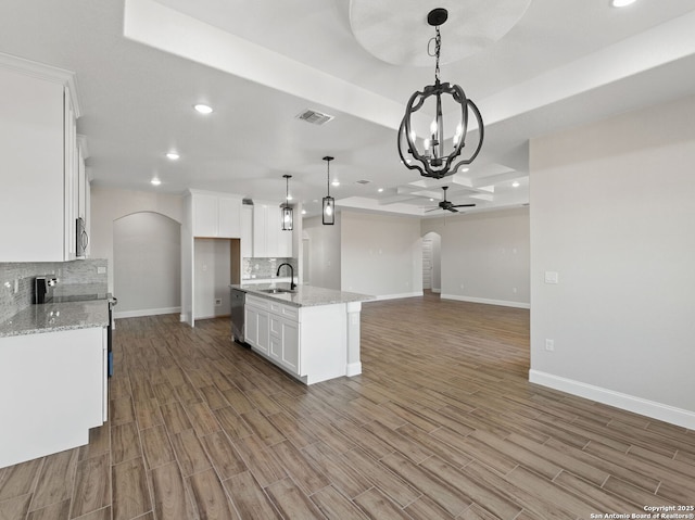 52 Peach Tree, Poteet, TX 78065 - kitchen featuring arched walkways, a sink, ceiling fan, backsplash, and white cabinets