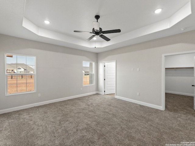 52 Peach Tree, Poteet, TX 78065 - unfurnished bedroom featuring a tray ceiling, carpet flooring, multiple windows, baseboards, and recessed lighting