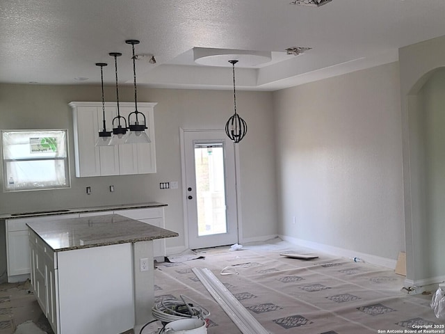 52 Peach Tree, Poteet, TX 78065 - kitchen with white cabinets, stone counters, hanging light fixtures, a raised ceiling, and a textured ceiling