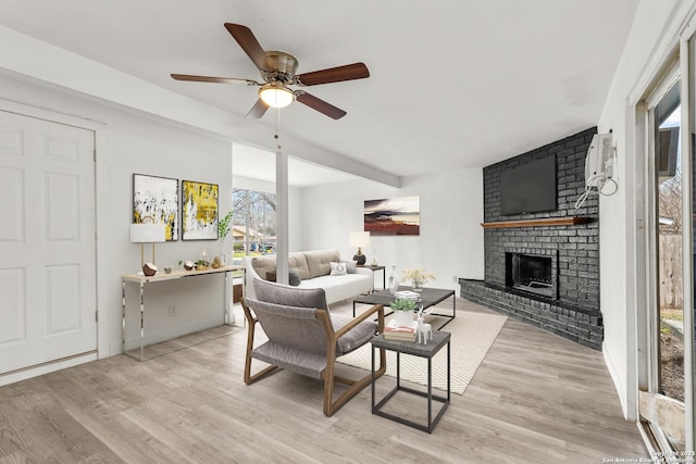 4419 El Simpatico, San Antonio, TX 78233 - living area with light wood-type flooring, a ceiling fan, and a brick fireplace