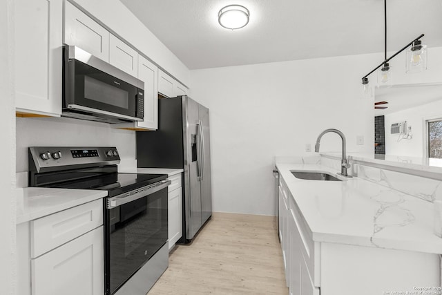 4419 El Simpatico, San Antonio, TX 78233 - kitchen featuring stainless steel appliances, a peninsula, a sink, light wood-style flooring, and white cabinetry
