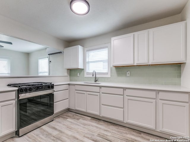 815 Flanders, San Antonio, TX 78211 - kitchen with gas range, a sink, light countertops, light wood finished floors, and white cabinetry