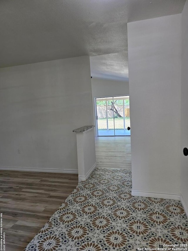 7401 Old Spanish Trl, Live Oak, TX 78233 - corridor with baseboards, lofted ceiling, a textured ceiling, and wood finished floors