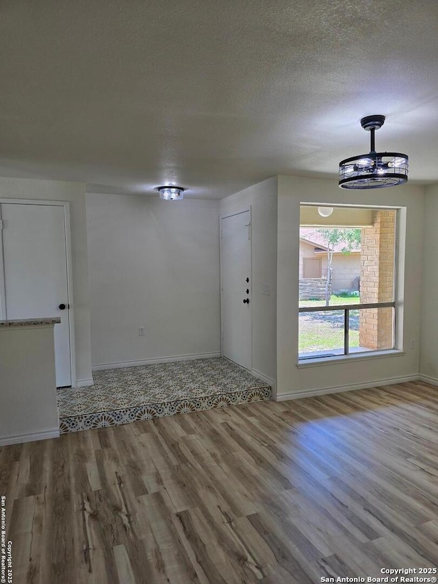 7401 Old Spanish Trl, Live Oak, TX 78233 - spare room with wood finished floors, baseboards, and a textured ceiling
