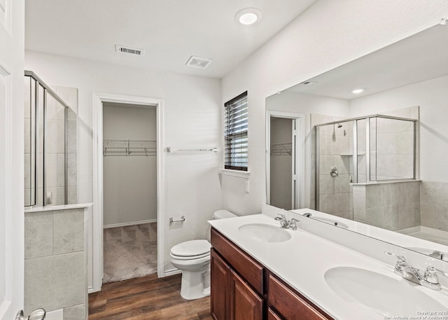 3175 Wild Indigo, New Braunfels, TX 78130 - bathroom with a spacious closet, wood finished floors, a stall shower, double vanity, and toilet