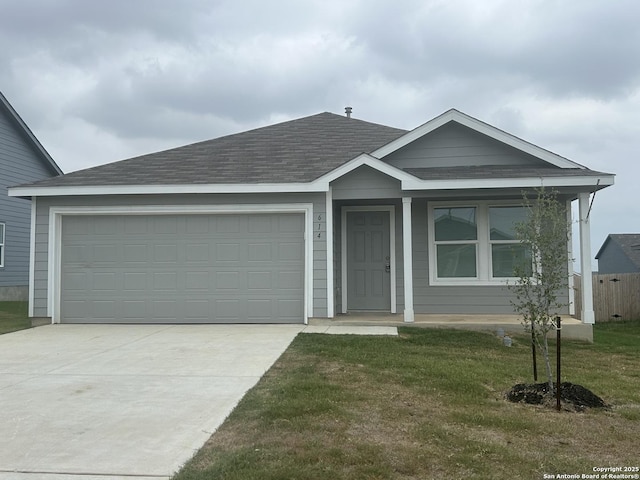 614 Agave, Jourdanton, TX 78026 - ranch-style house with a shingled roof, concrete driveway, an attached garage, and a front lawn