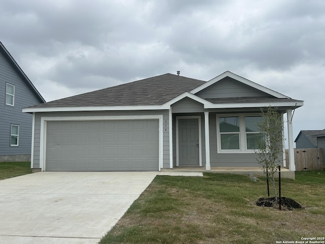 614 Agave, Jourdanton, TX 78026 - ranch-style home featuring driveway, a garage, roof with shingles, and a front lawn