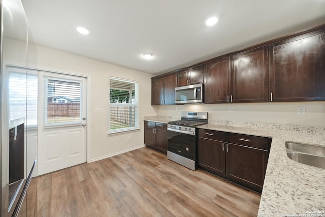 7341 Yucca Pl, San Antonio, TX 78253 - kitchen with stainless steel appliances, light wood finished floors, dark brown cabinets, light stone countertops, and recessed lighting