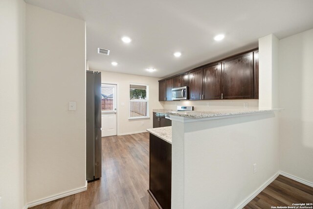 7341 Yucca Pl, San Antonio, TX 78253 - kitchen with appliances with stainless steel finishes, dark brown cabinetry, light wood-style floors, and recessed lighting