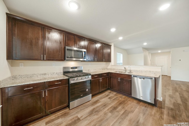 7341 Yucca Pl, San Antonio, TX 78253 - kitchen with appliances with stainless steel finishes, light wood-style floors, a sink, dark brown cabinets, and light stone countertops