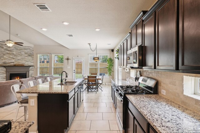 32003 Cast Iron, Bulverde, TX 78163 - kitchen with stainless steel appliances, a sink, open floor plan, a ceiling fan, and a breakfast bar
