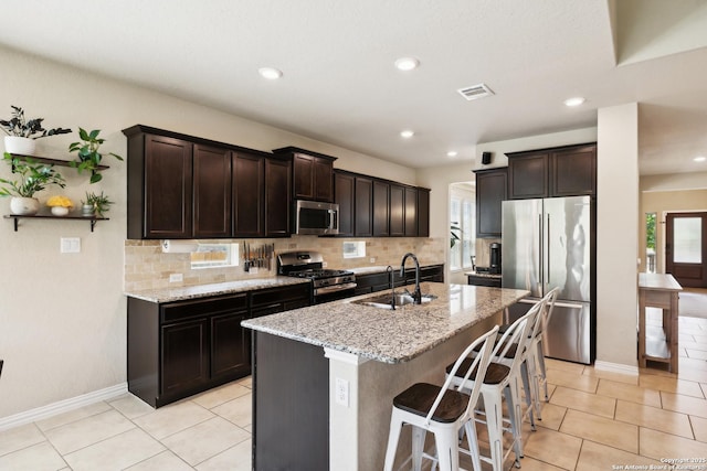 32003 Cast Iron, Bulverde, TX 78163 - kitchen with stainless steel appliances, a sink, decorative backsplash, light stone counters, and a center island with sink