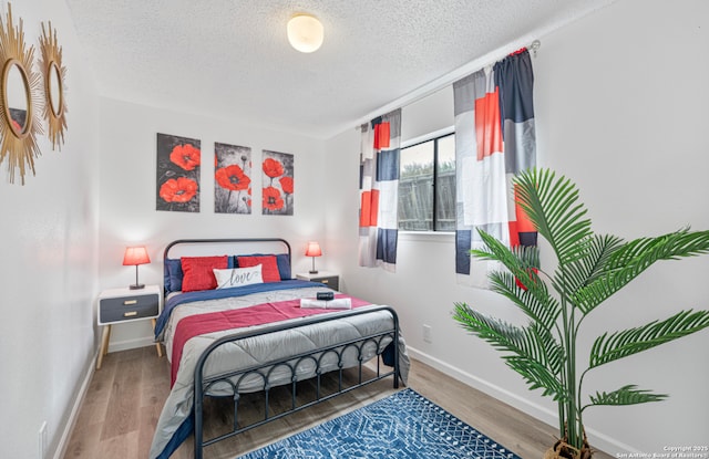 9630 NW Simplicity Dr, San Antonio, TX 78245 - bedroom with a textured ceiling, wood finished floors, and baseboards