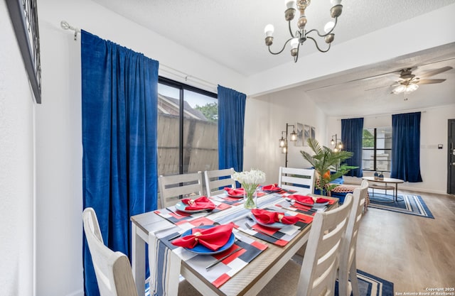 9630 NW Simplicity Dr, San Antonio, TX 78245 - dining room with wood finished floors, a chandelier, a textured ceiling, ceiling fan, and baseboards