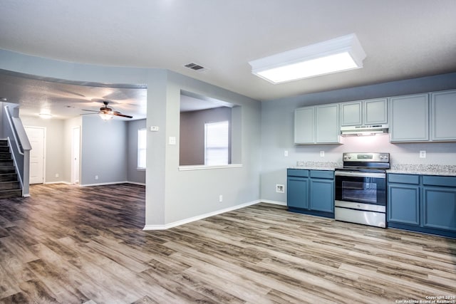 510 Hampton Cv, Boerne, TX 78006 - kitchen with stainless steel electric range oven, under cabinet range hood, light wood-style floors, ceiling fan, and blue cabinetry