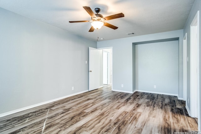 510 Hampton Cv, Boerne, TX 78006 - unfurnished bedroom with wood finished floors, baseboards, and a ceiling fan