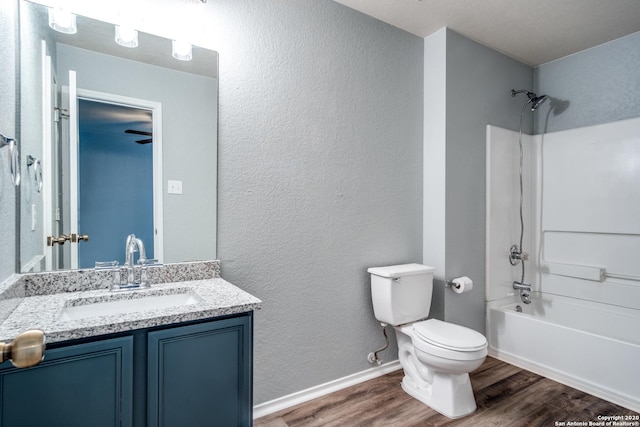 510 Hampton Cv, Boerne, TX 78006 - bathroom featuring vanity, toilet, wood finished floors, bathing tub / shower combination, and a textured wall