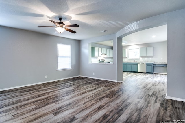 510 Hampton Cv, Boerne, TX 78006 - unfurnished living room featuring dark wood finished floors, plenty of natural light, a sink, and baseboards