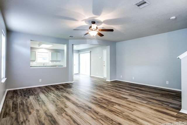 510 Hampton Cv, Boerne, TX 78006 - unfurnished living room featuring dark wood-type flooring, ceiling fan, and baseboards