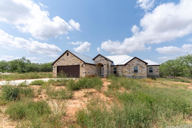 14674 Silesia Dr, Saint Hedwig, TX 78152 - view of front of house featuring stone siding, a garage, a standing seam roof, and metal roof