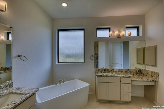 23350 Grande Vis, San Antonio, TX 78261 - full bathroom featuring a freestanding tub, two vanities, tile patterned floors, and baseboards
