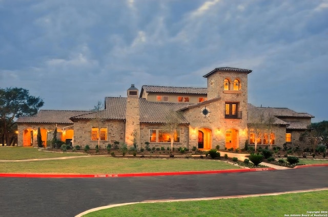 23350 Grande Vis, San Antonio, TX 78261 - mediterranean / spanish house featuring a chimney, stone siding, a front lawn, and a tiled roof