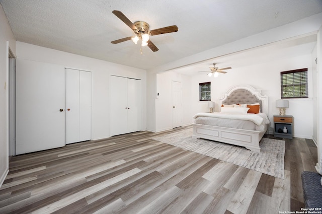 7035 Forest Mdw, San Antonio, TX 78240 - bedroom with two closets, wood finished floors, a ceiling fan, and baseboards