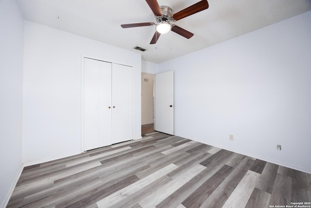 7035 Forest Mdw, San Antonio, TX 78240 - unfurnished bedroom featuring wood finished floors, a closet, and a ceiling fan