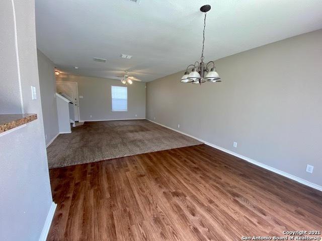 6926 Lunar Way, San Antonio, TX 78109 - unfurnished living room with wood finished floors, a ceiling fan, a chandelier, and baseboards