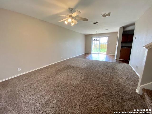 6926 Lunar Way, San Antonio, TX 78109 - spare room with dark carpet, a ceiling fan, baseboards, and a chandelier